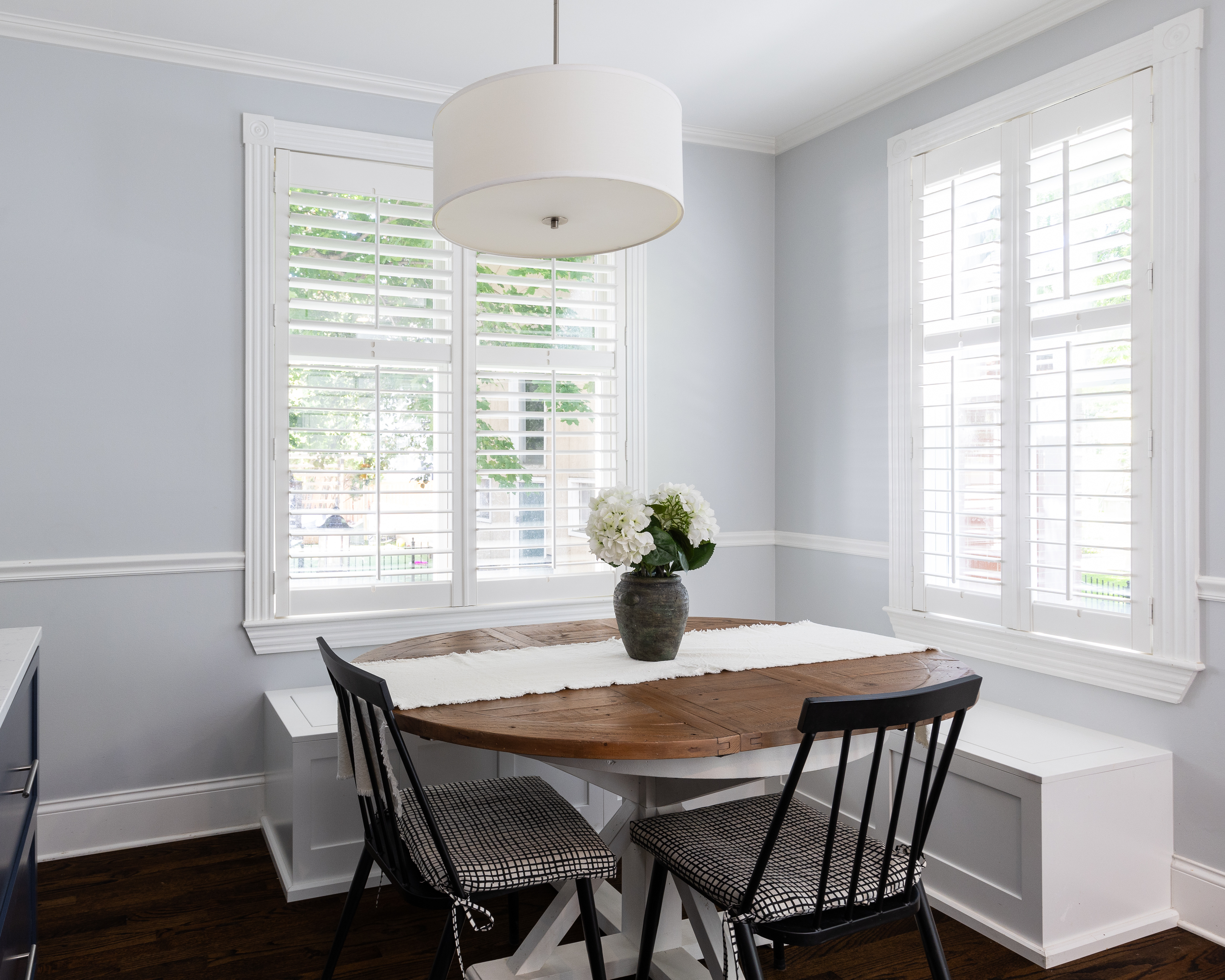 White plantation shutters fitted in a light dining room, bringing natural light, privacy, and style to a home in Sutton Coldfield.