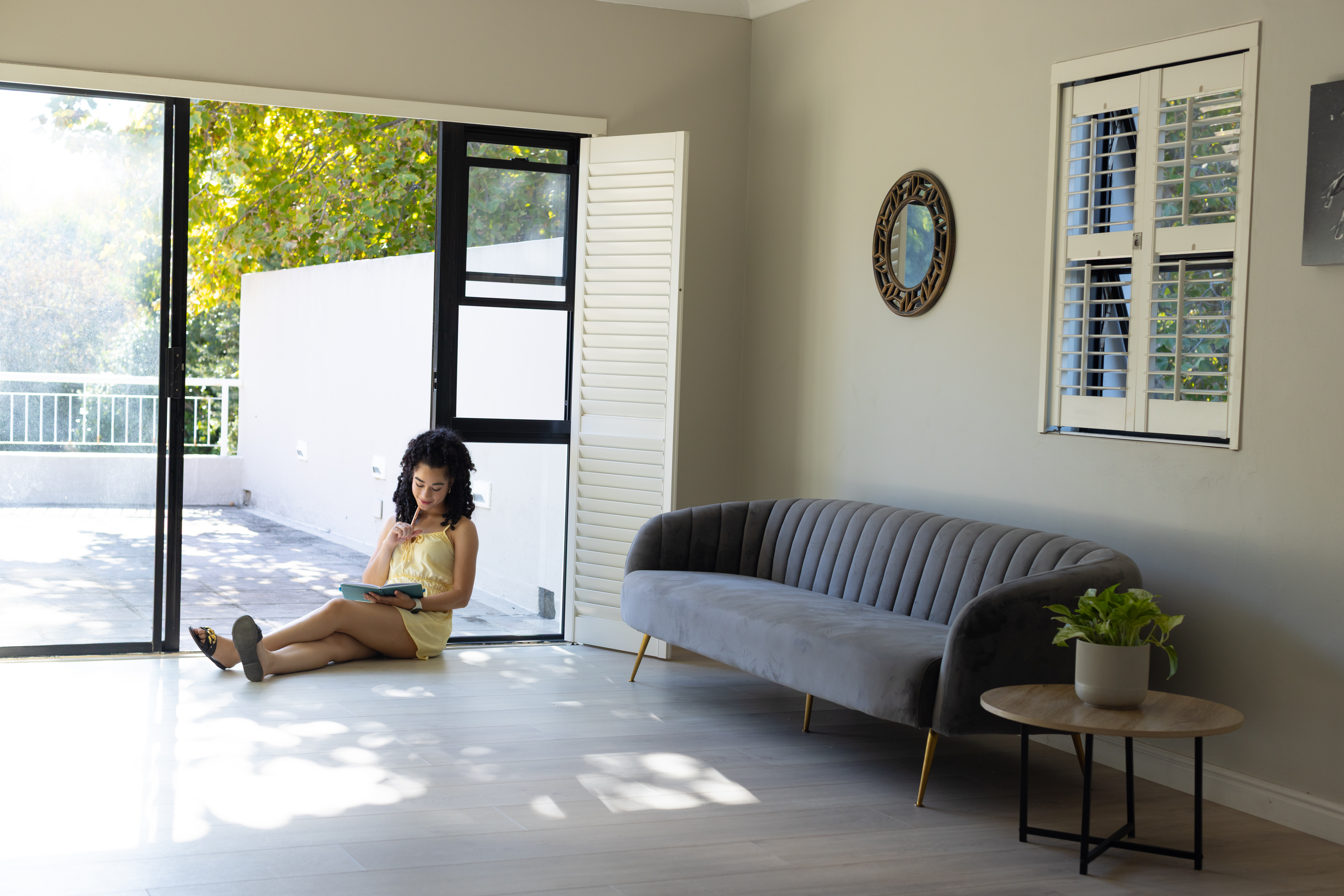 Young woman sitting in front of shutters