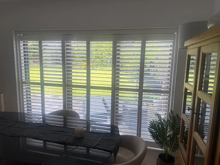 Made-to-measure full-height plantation shutters fitted across a large glazed door opening in a West Midlands home
